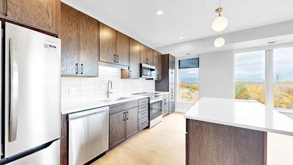 A modern kitchen with stainless steel appliances and wooden cabinets.