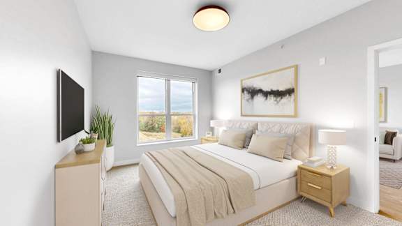 A bedroom with a large bed, a flat screen TV, and a window overlooking the ocean.