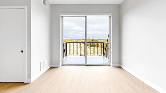 A room with a white door and a large window with a view of the ocean.
