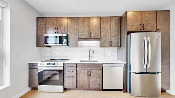 A modern kitchen with wooden cabinets and stainless steel appliances.