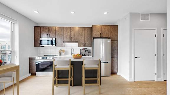 A modern kitchen with wooden cabinets and stainless steel appliances.