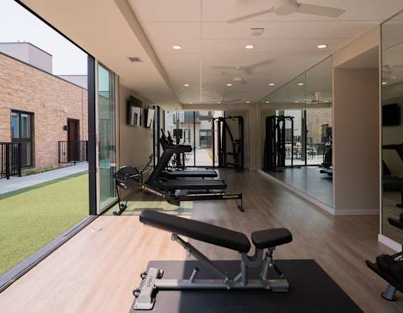 A gym with a variety of equipment including treadmills and weights.