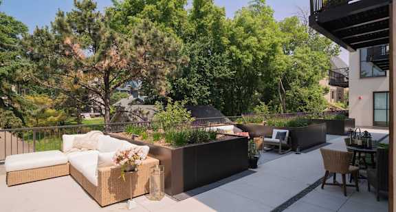 A patio with a white couch and a table with chairs.