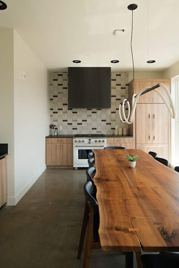 A modern kitchen with a wooden table and chairs.