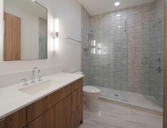 A modern bathroom with a glass shower stall and a white sink.