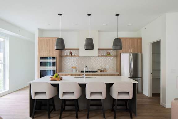 A kitchen with a table and chairs.