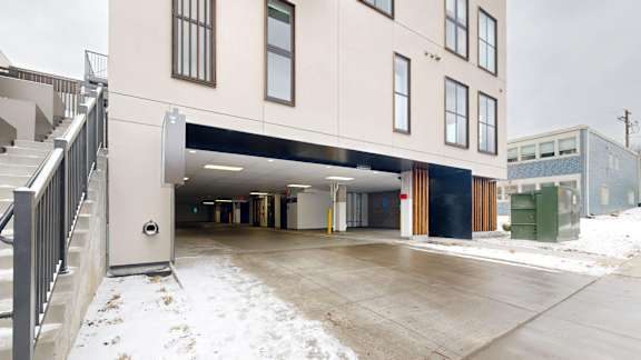 A building with a covered parking area in front.