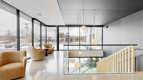 A modern interior with a glass wall and a staircase.
