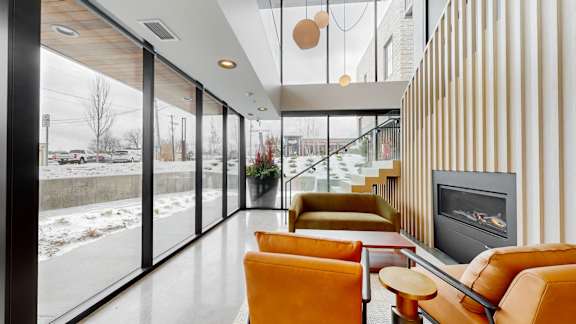 A modern living room with a fireplace and a view of the outdoors.