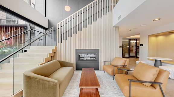 A living room with a tan couch and a wooden coffee table.