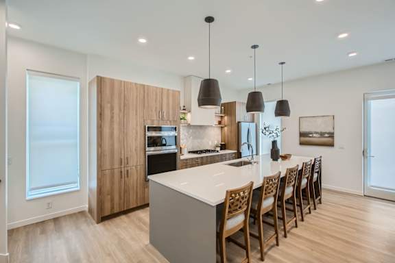 a kitchen with a large island and chairs at One West Drive Apartments, Excelsior, 55331