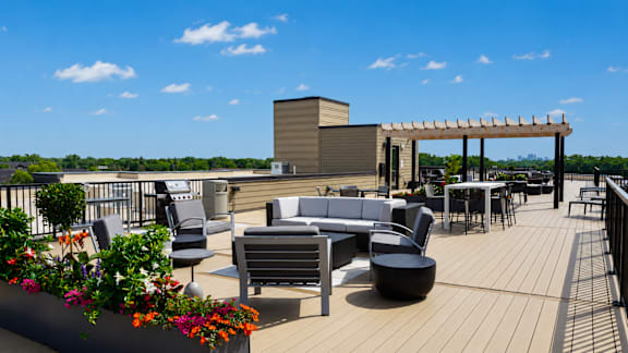 A rooftop patio with a table and chairs.