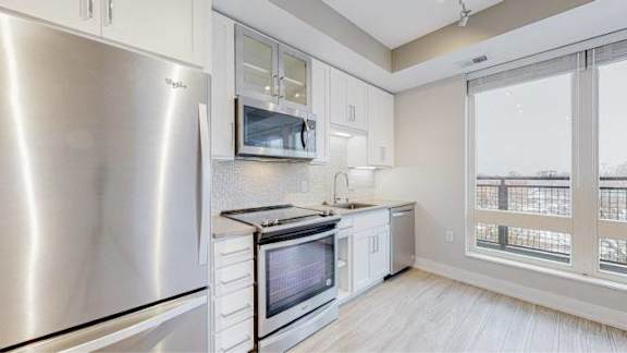 A modern kitchen with stainless steel appliances and white cabinets.