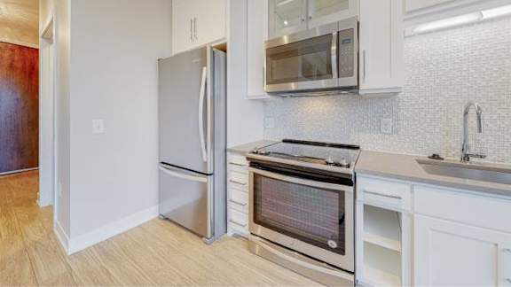 A kitchen with a stainless steel refrigerator and oven.
