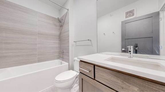 A white toilet sits next to a sink in a modern bathroom.