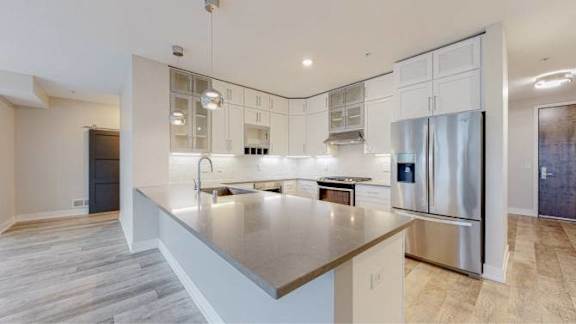 A modern kitchen with a large island and stainless steel appliances.