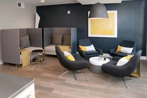 A modern living room with grey and yellow accents.