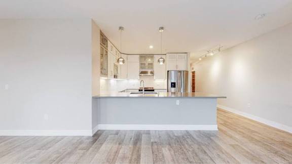 A kitchen with a wooden floor and white walls.