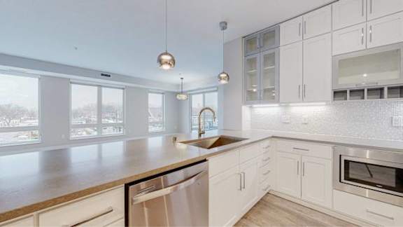A modern kitchen with white cabinets and a wooden countertop.