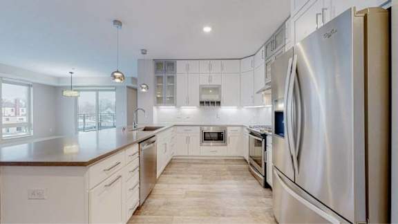 A modern kitchen with a large island and stainless steel appliances.