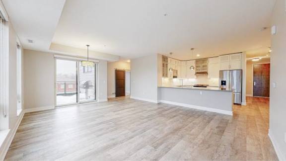 A spacious room with wooden flooring and white walls.