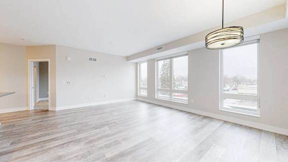 A room with a wooden floor and a hanging light fixture.