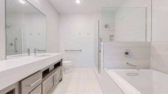 A white bathroom with a walk in shower.