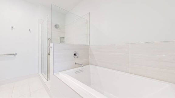 A white bathroom with a glass shower door.