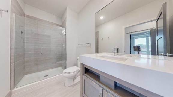 A modern bathroom with a walk-in shower and double sink vanity.