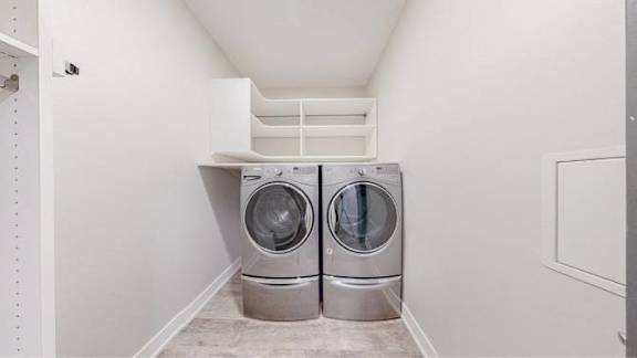 A pair of front loading washing machines in a laundry room.