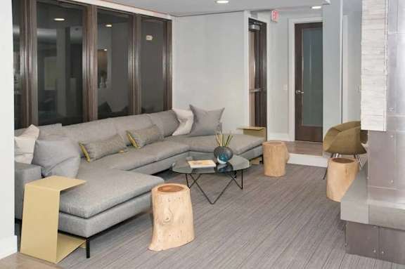 A grey sofa with a coffee table in front of it.