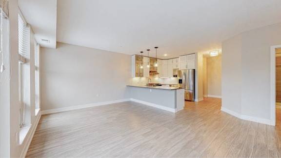 A kitchen area with a counter and a refrigerator.