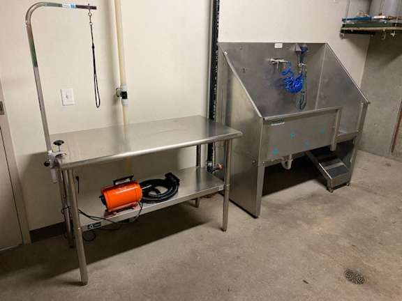 A stainless steel work table with a red container on it.