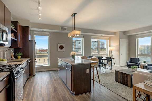 A modern kitchen with a large island and a view of the city.