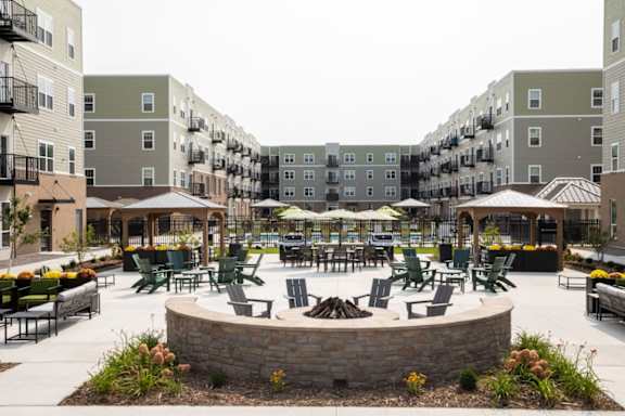 A courtyard with a fire pit surrounded by apartment buildings.