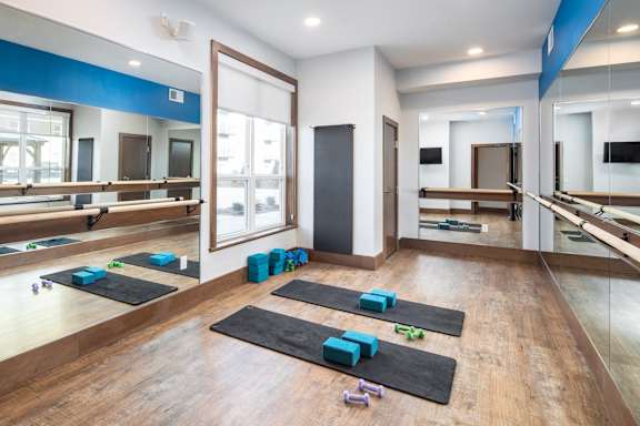 A yoga studio with mats and blocks on the floor.