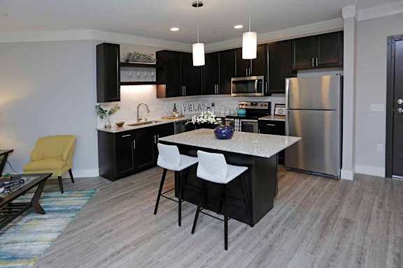 A modern kitchen with a large island and stainless steel appliances.
