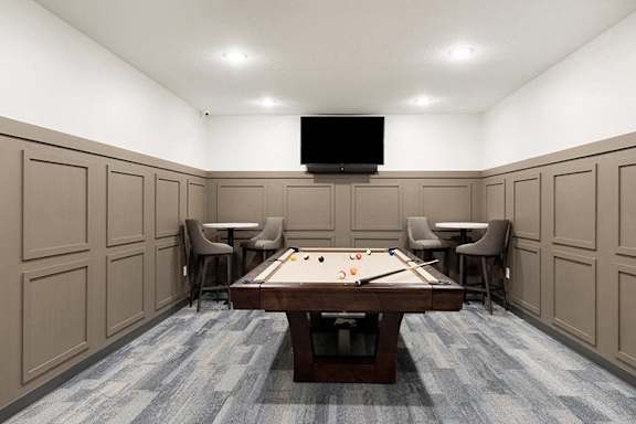 A room with a pool table and chairs at The Barnum Apartments, Minnesota