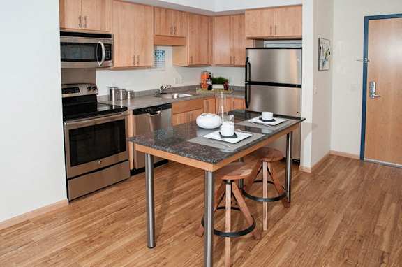 A kitchen with a table and chairs in the middle of it.