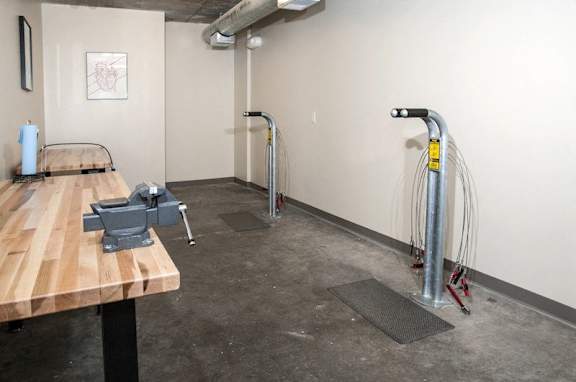 A gym with a bench, weights and a pull up bar.