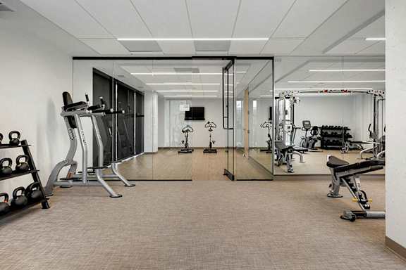 A spacious gym with a variety of equipment including treadmills, weights, and exercise machines.at Viridium Apartments, Minneapolis, MN 55401