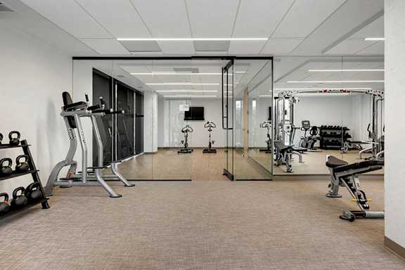 A spacious gym with a variety of equipment including treadmills, weights, and exercise machines.at Viridium Apartments, Minneapolis, MN 55401