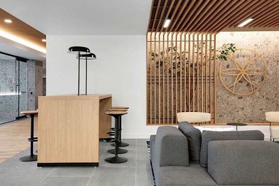 A reception area with a wooden counter and grey couches.at Viridium Apartments, Minnesota, 55401