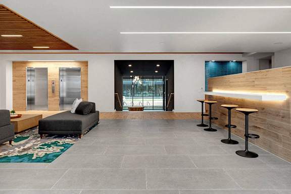 A modern living room with a grey floor and a wooden ceiling.at Viridium Apartments, Minneapolis