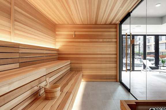 A wooden sauna room with a glass door leading to a balcony.at Viridium Apartments, Minneapolis