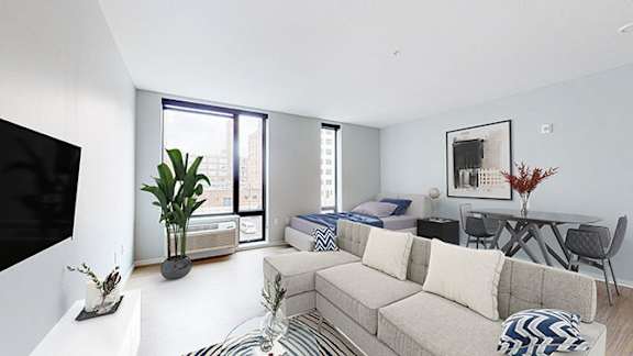 A living room with a couch, a table, and a television.at Viridium Apartments, Minneapolis, MN