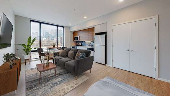 A modern living room with a grey couch and a wooden coffee table.at Viridium Apartments, Minneapolis, 55401