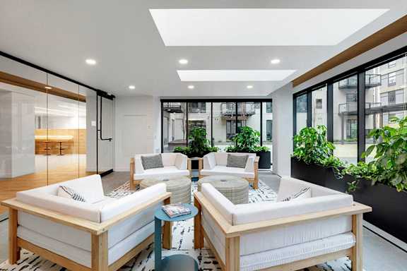 A modern living room with white furniture and a large window.at Viridium Apartments, Minneapolis, 55401