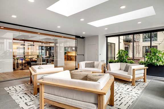A modern living room with a glass wall and a skylight.at Viridium Apartments, Minnesota, 55401