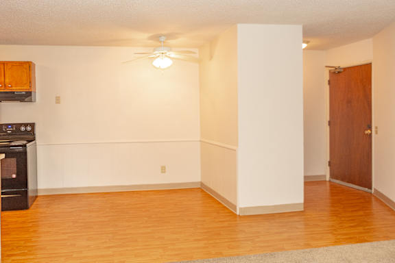 A room with a ceiling fan and a door.